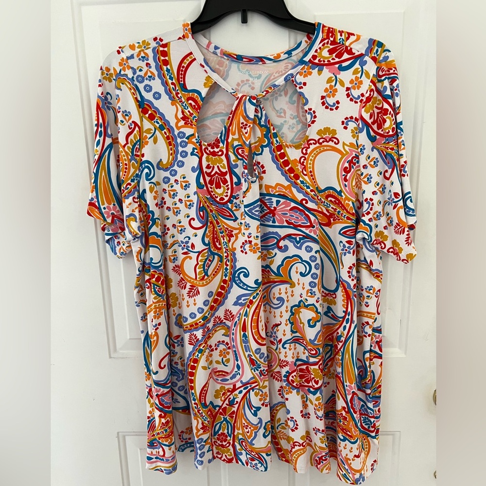 Women’s multicolor short sleeve knit tunic with twist neckline. Size 22/24.